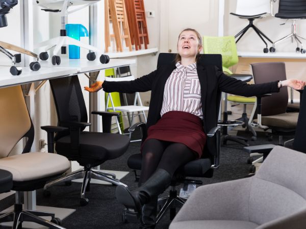 Photo of a lady trying out chairs for a meeting room.