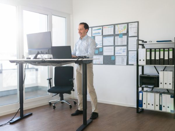 Photo of an employee using a sit-stand desk.