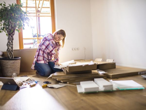 Photo of business owner, building a flatpack desk for her new office space.