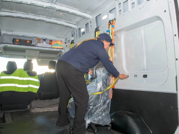 Photo of Tamara securing a chair in the delivery van after assembling it for the client.